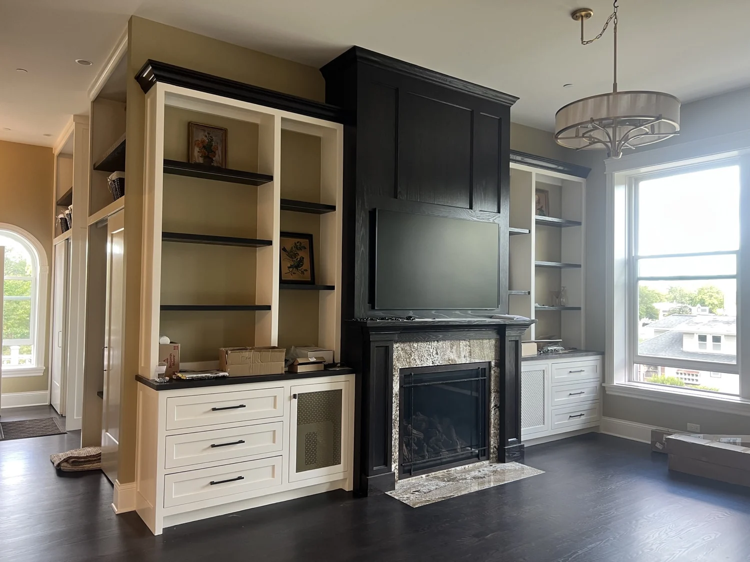Black fireplace surround with white built-in cabinetry and shelving