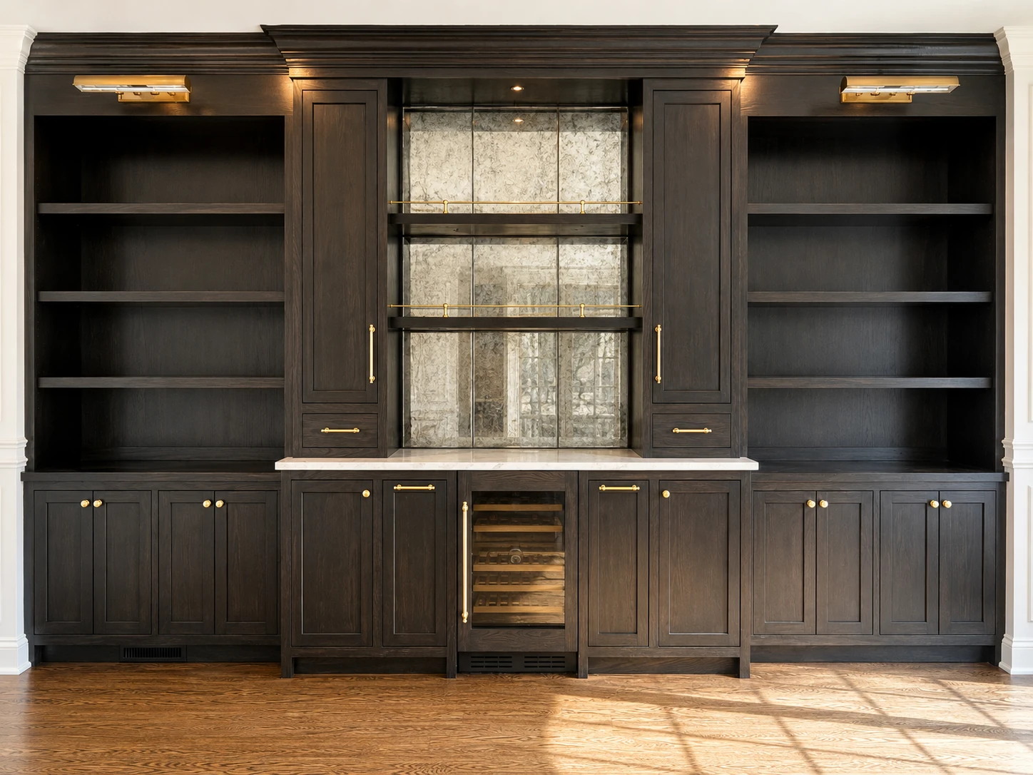Stained oak wall cabinetry with brass hardware